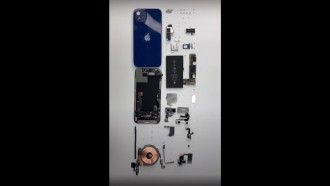 iPhone 12 is disassembled showing Qualcomm X55 5G modem and 1815 mAh battery